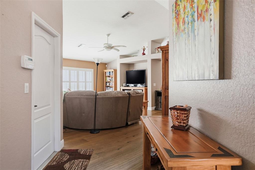 A view from a hallway into a living room with a sectional sofa and television — 363 ROYAL PALM WAY, SPRING HILL, FL