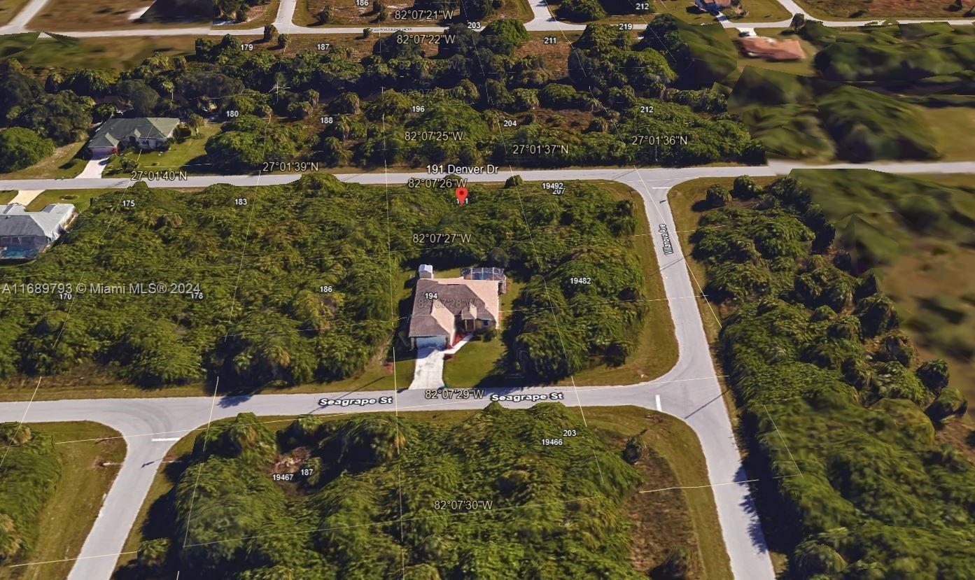 This aerial view shows a single-family home situated on a corner lot with dense vegetation — PORT CHARLOTTE, FL
