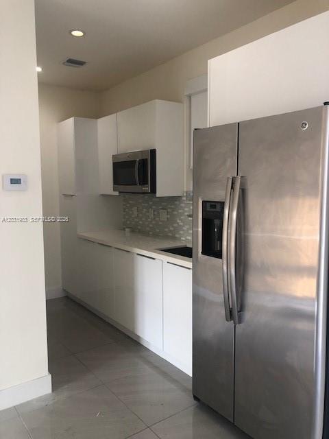 A modern kitchen features white cabinets, stainless steel appliances, and a tiled backsplash — 6316 NW 105th Pl # 0, Miami FL 33178, MIAMI, FL