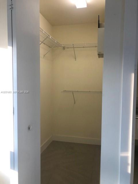 A walk-in closet with white walls, gray tile flooring, and white wire shelving — 6316 NW 105th Pl # 0, Miami FL 33178, MIAMI, FL
