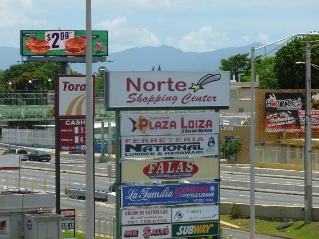 A tall sign displays the Norte Shopping Center directory alongside a digital billboard and highway — 0 BALDORIOTY DE CASTRO AVE. INT. ARCOIRIS, SAN JUAN, PR