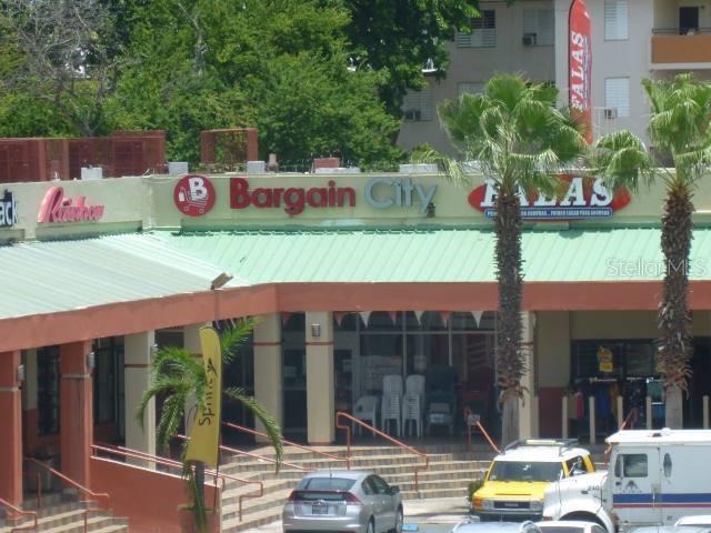 A shopping center exterior features a Bargain City store with a green roof and palm trees — 0 BALDORIOTY DE CASTRO AVE. INT. ARCOIRIS, SAN JUAN, PR