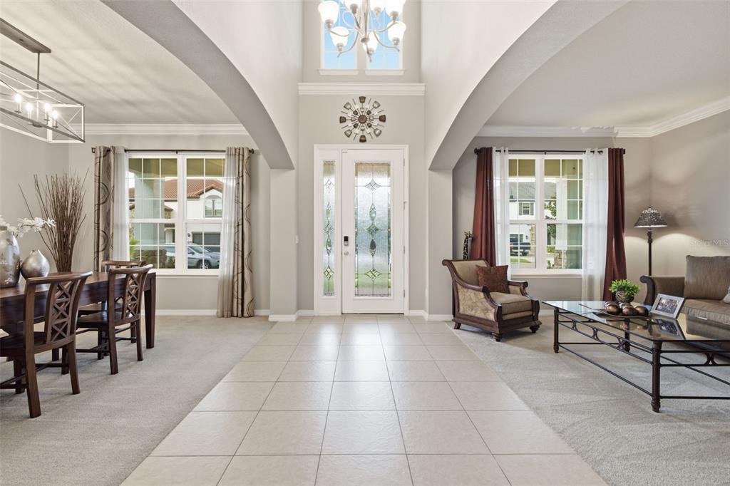 A bright foyer with tile flooring leads to a dining room and living area — 19385 PUMMELO DRIVE, ORLANDO, FL