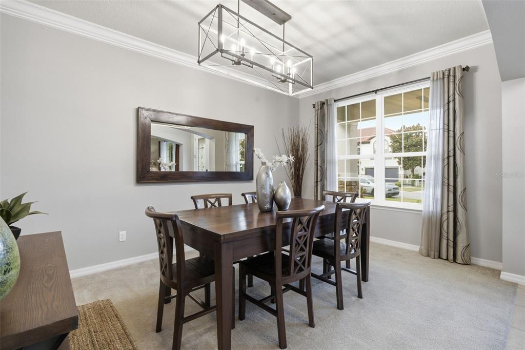 A dining room features a wooden table, four chairs, a rectangular mirror, and a chandelier — 19385 PUMMELO DRIVE, ORLANDO, FL