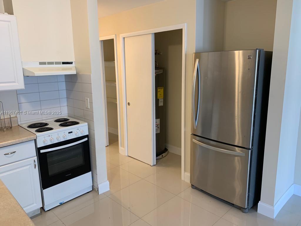 A kitchen features white cabinets, a white electric stove, and a stainless steel refrigerator — 1511 NE 117th St # 2, Miami FL 33161, MIAMI, FL