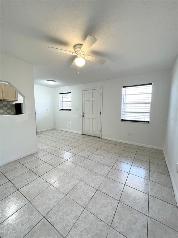 A room with light-colored tile flooring, a ceiling fan, and a white door — 2916 NORTH 16TH STREET UNIT 2, TAMPA, FL