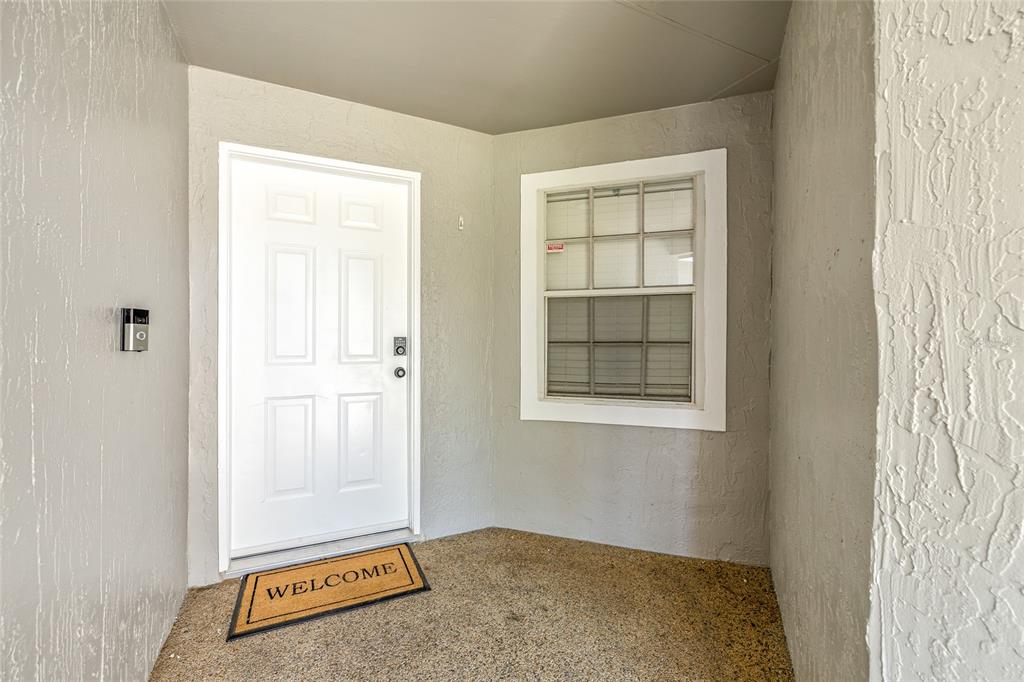 A front entryway features a white door, a window, and a welcome mat on the porch — 404 EMERALD COVE LOOP, LAKELAND, FL