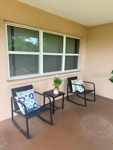 Two outdoor rocking chairs and a small side table sit on a covered porch — 830 55TH AVENUE S, ST PETERSBURG, FL
