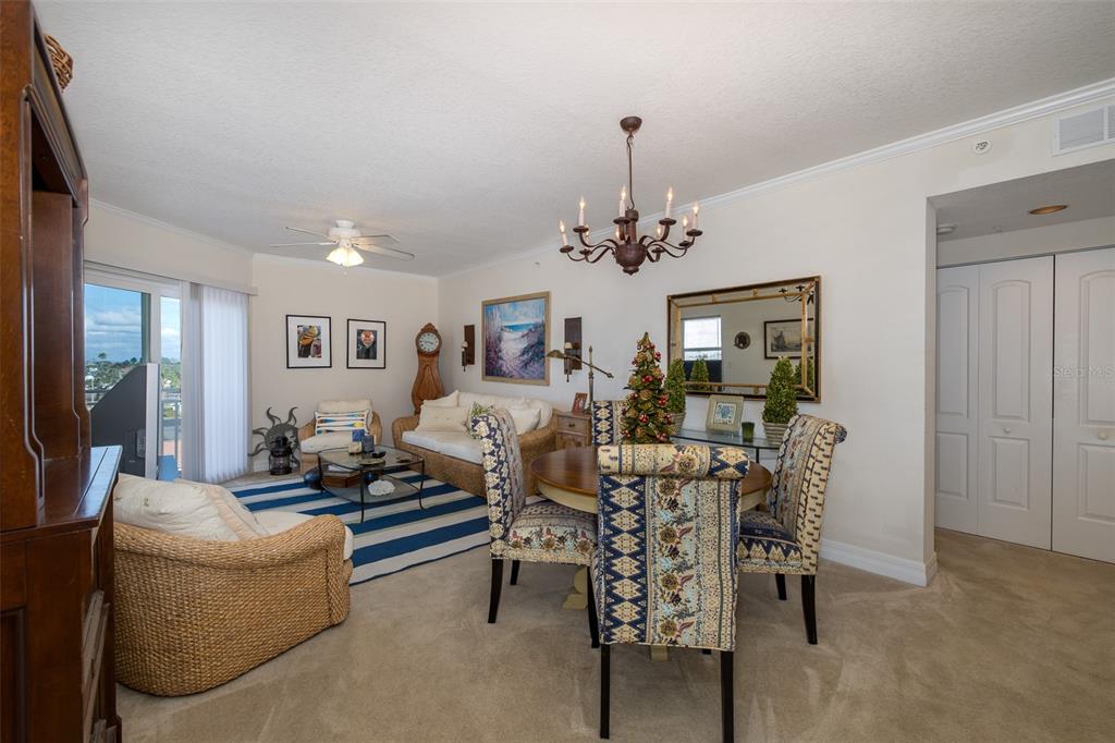 A living and dining area with wicker furniture, a striped rug, and a chandelier — 4516 SEAGULL DRIVE UNIT 413, NEW PORT RICHEY, FL
