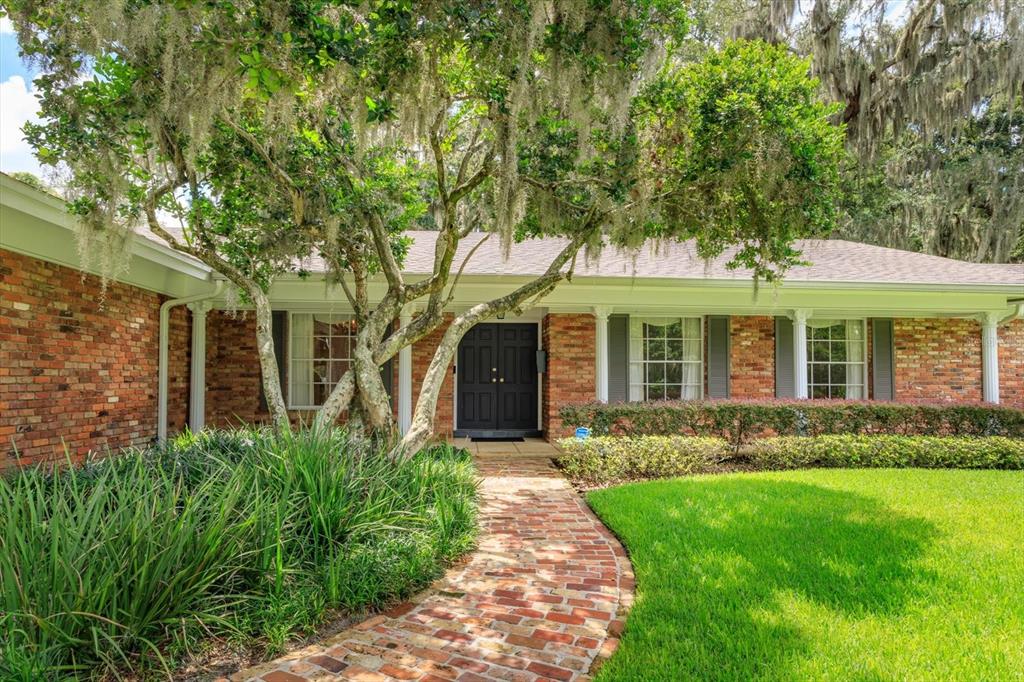 A brick house with a front walkway and large trees covered in Spanish moss — 5019 GRAN LAC AVENUE, ORLANDO, FL