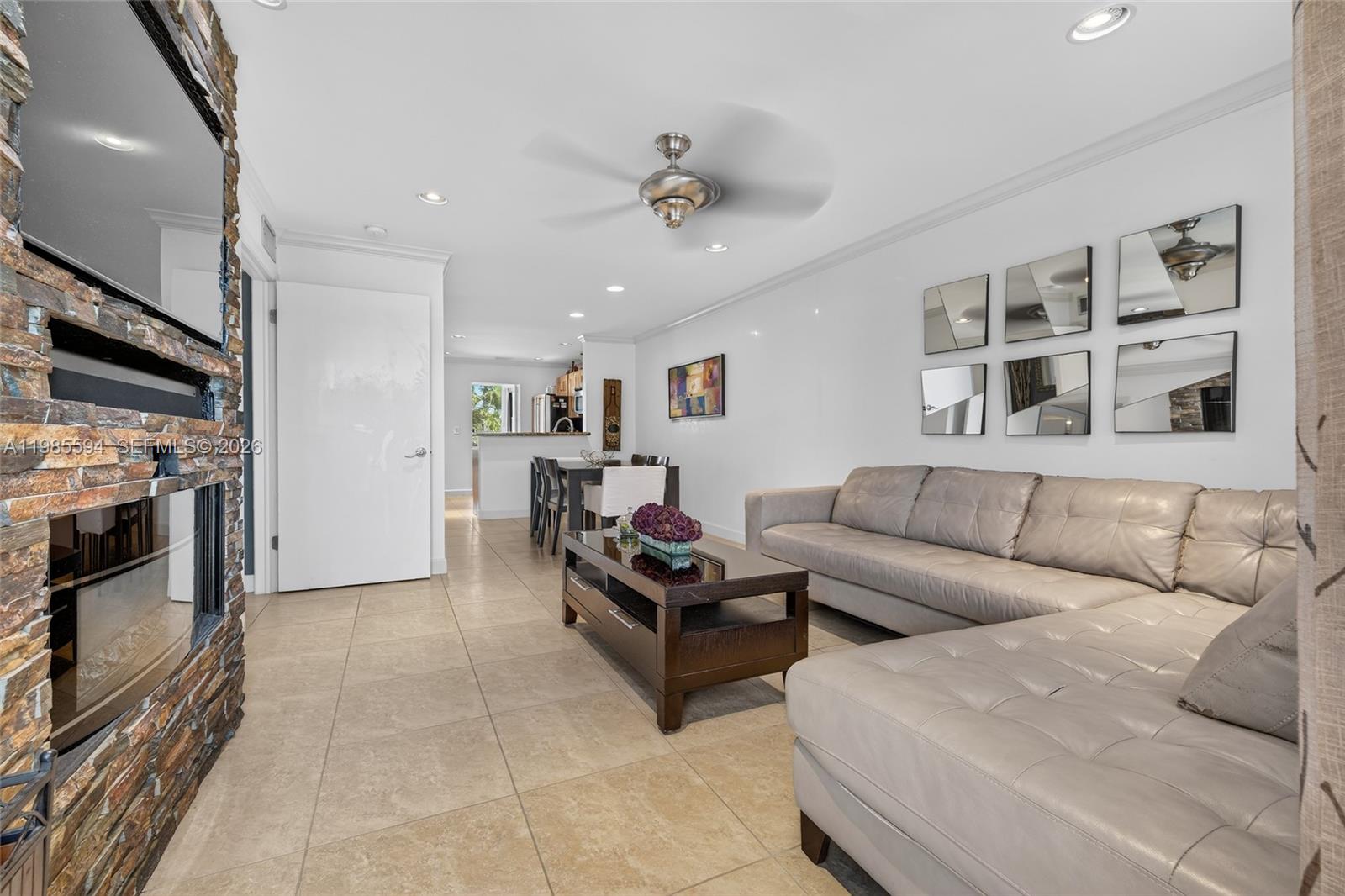 A living room features a stone fireplace, a sectional sofa, and tile flooring — 3777 NW 78th Ave # 8F, Davie FL 33024, DAVIE, FL