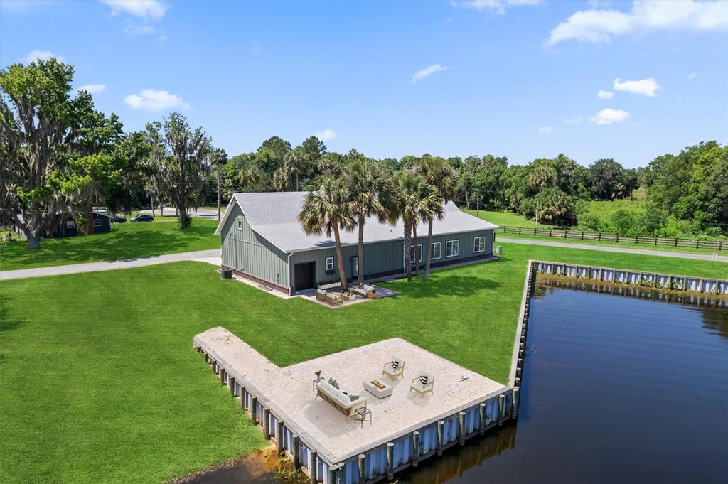 An aerial view shows several waterfront homes situated on a grassy peninsula with private docks — 3943 NW 219TH STREET ROAD, MICANOPY, FL