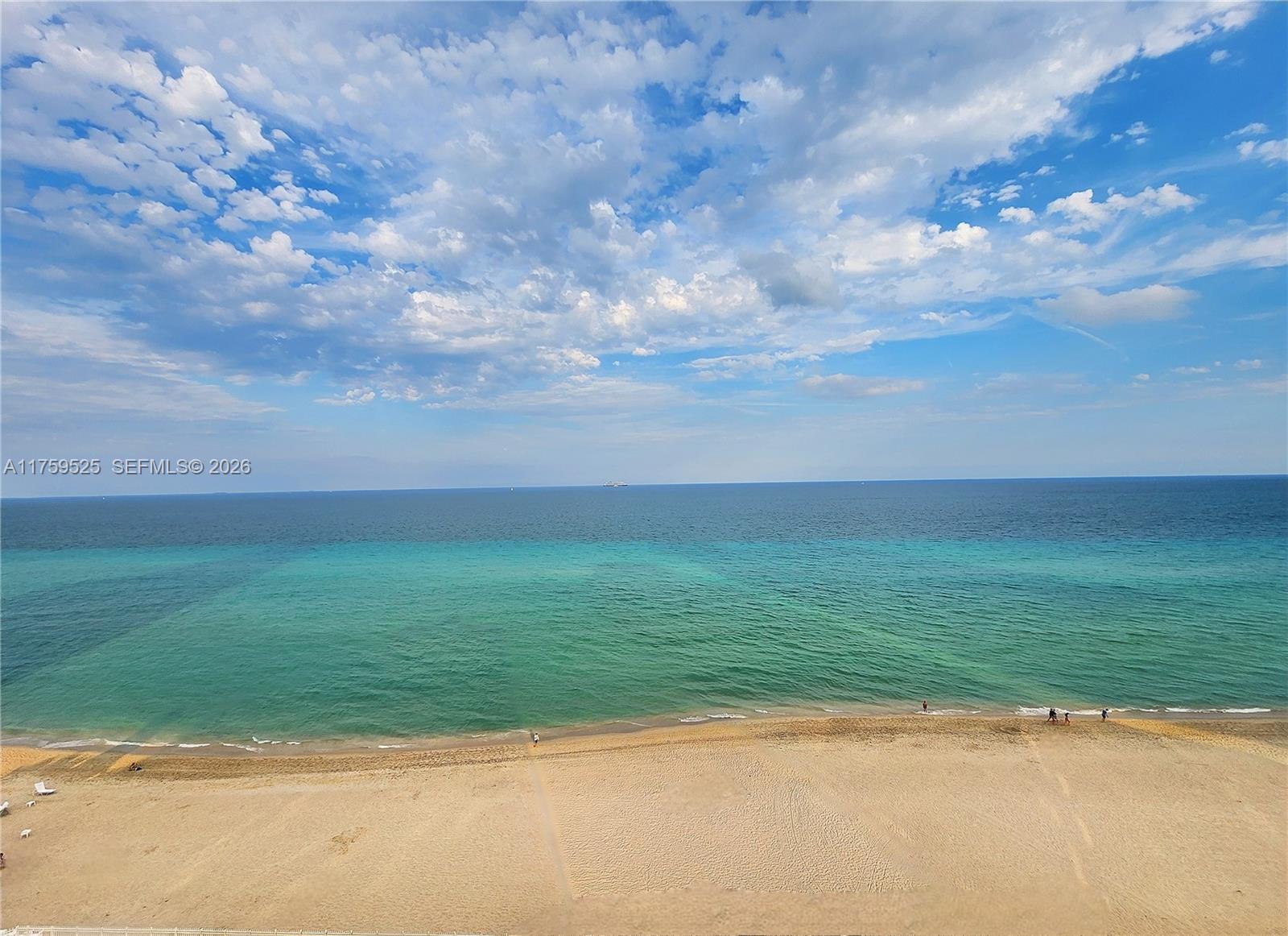 An elevated view of a sandy beach meeting the turquoise ocean under a cloudy sky — 3505 S Ocean Dr # 1014, Hollywood FL 33019, HOLLYWOOD, FL