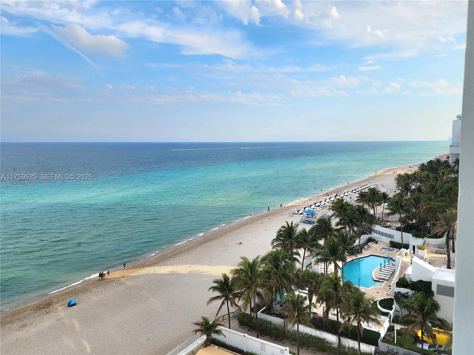 An elevated view of a sandy beach, turquoise ocean, and a resort swimming pool — 3505 S Ocean Dr # 1014, Hollywood FL 33019, HOLLYWOOD, FL