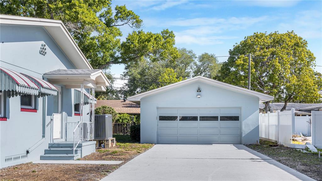 A light blue house with a matching detached garage and a concrete driveway — 4725 DEL RIO WAY S, GULFPORT, FL