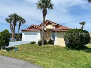A single-story house with a two-car garage, palm trees, and a manicured lawn — 30 SAN RAFAEL COURT, PALM COAST, FL