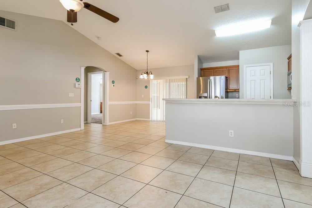 A tiled dining area and kitchen with a breakfast bar and vaulted ceilings — 926 WILLOW RUN STREET, MINNEOLA, FL