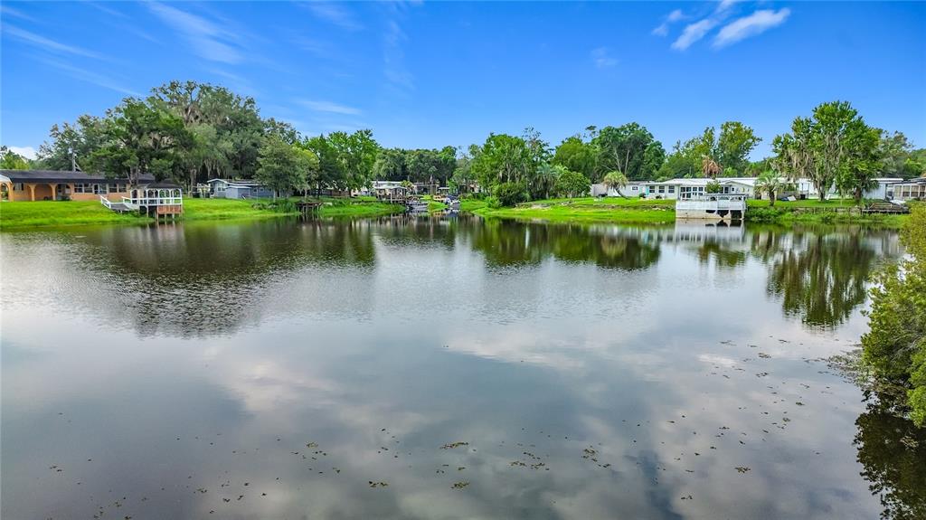A view of a calm lake surrounded by residential homes and lush green trees — 10116 E GULF TO LAKE HIGHWAY, INVERNESS, FL