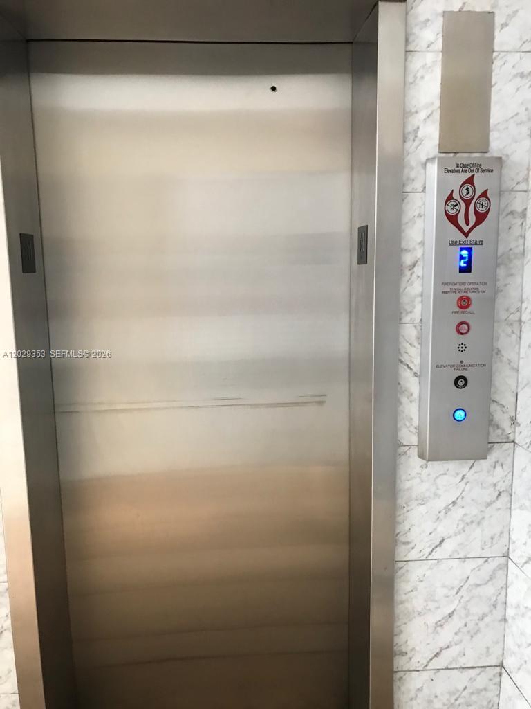 An elevator with a stainless steel door and a control panel on a marble wall — 5505 NW 7th St # W417, Miami FL 33126, MIAMI, FL