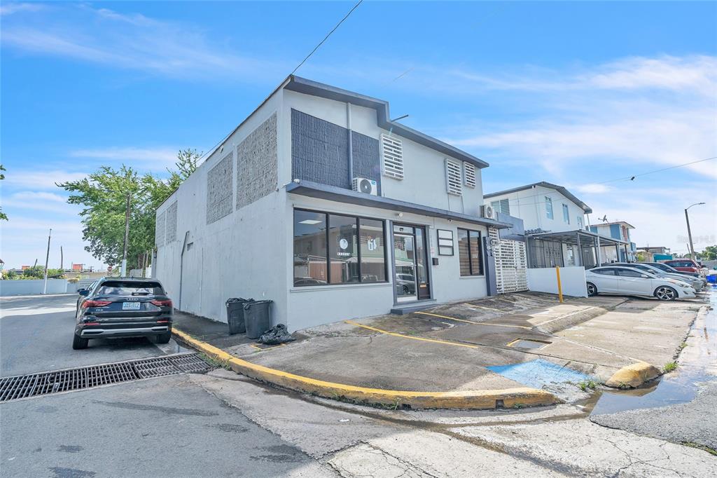 A two-story commercial building with a gray facade, large front windows, and paved parking spaces — 1000 8SE ANDALUCÍA, PUERTO NUEVO, PR