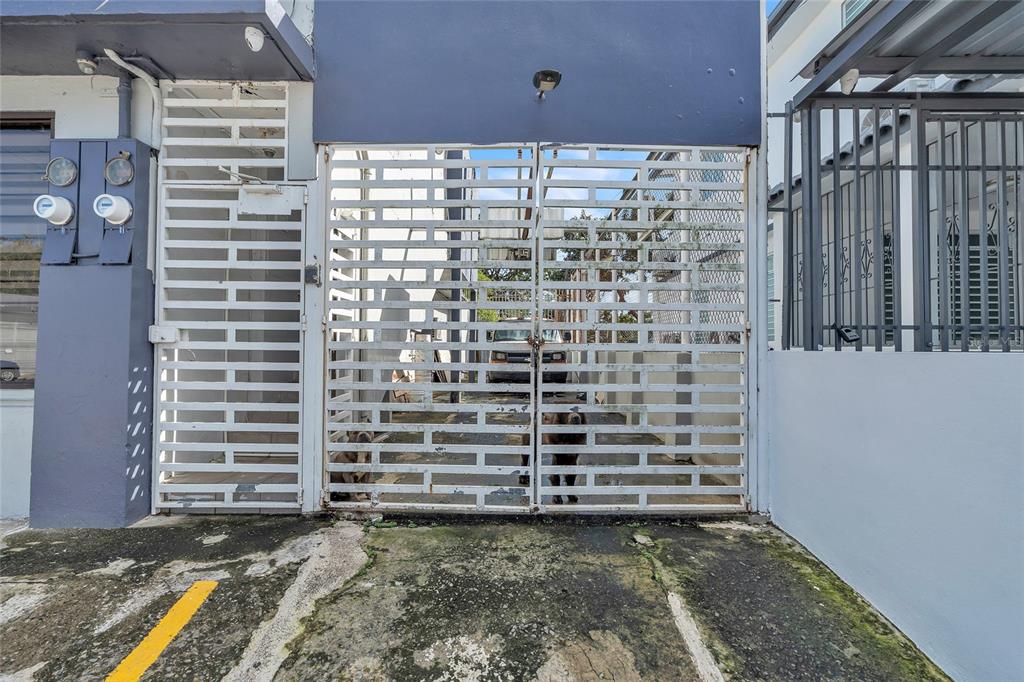 A white metal gate secures a narrow driveway between two buildings — 1000 8SE ANDALUCÍA, PUERTO NUEVO, PR