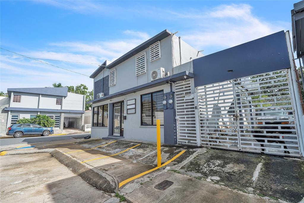 A two-story gray commercial building features a gated entrance, parking spaces, and a blue car — 1000 8SE ANDALUCÍA, PUERTO NUEVO, PR
