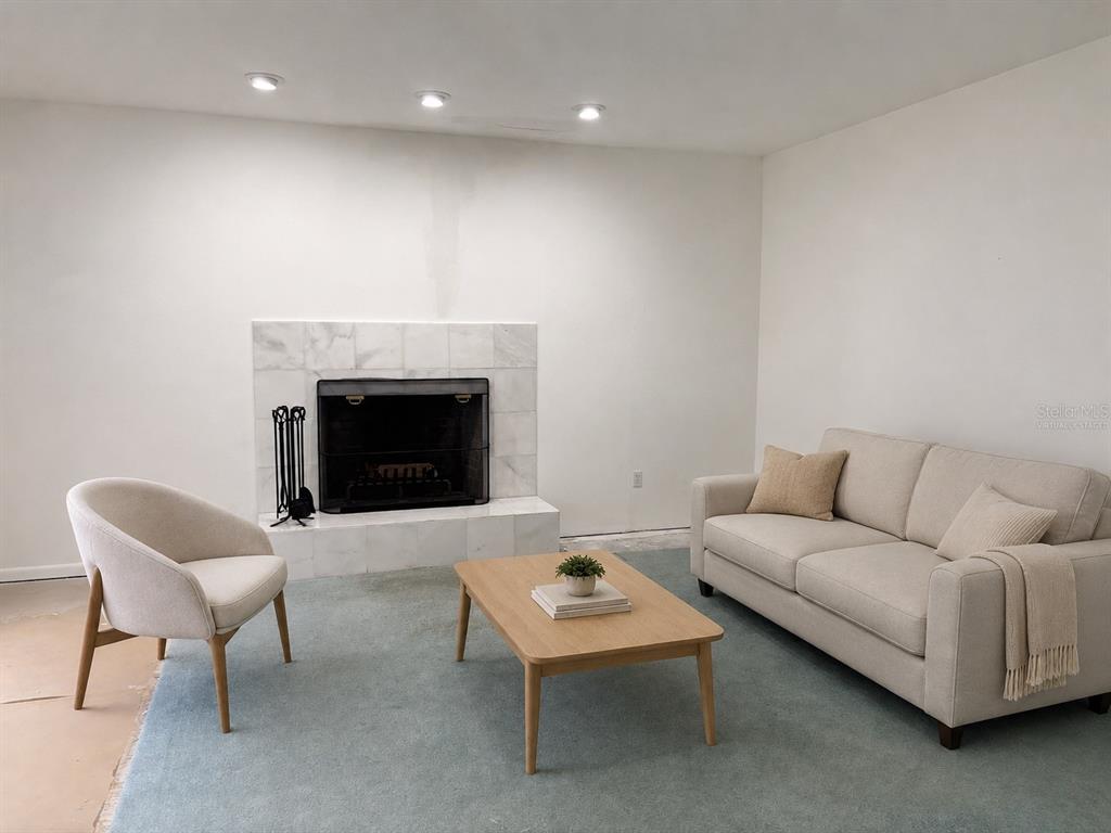 A living room features a marble fireplace, a light-colored sofa, an armchair, and a rug — 6407 NW 132ND STREET, GAINESVILLE, FL