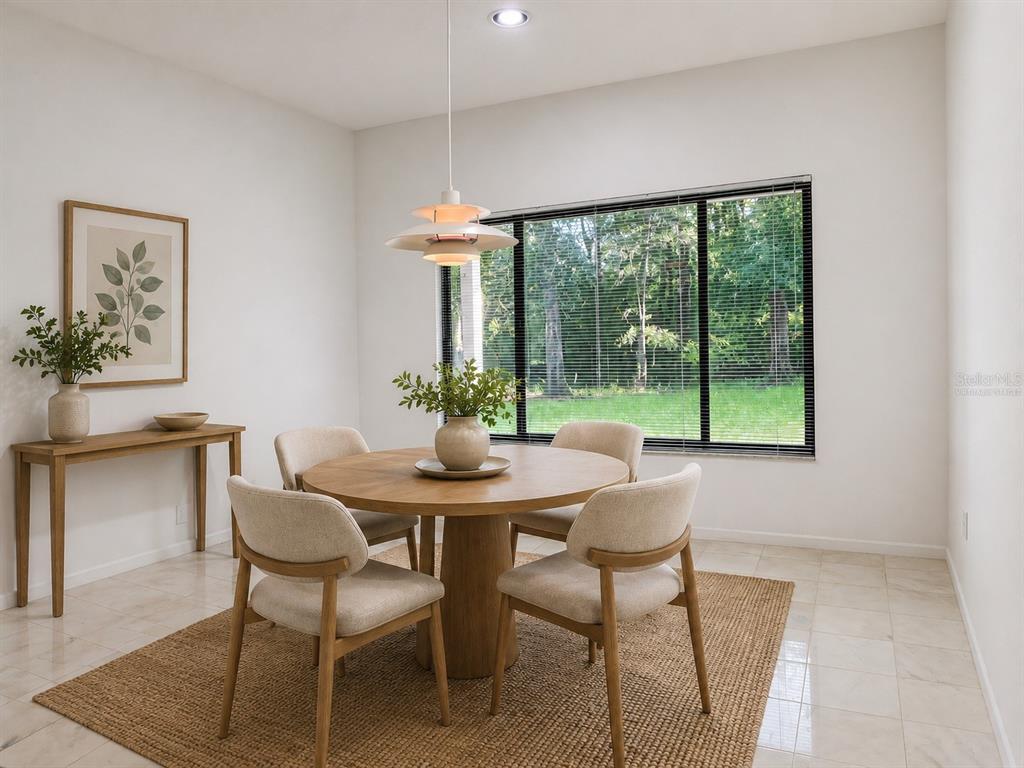 A dining room features a round wooden table, four upholstered chairs, and a large window — 6407 NW 132ND STREET, GAINESVILLE, FL