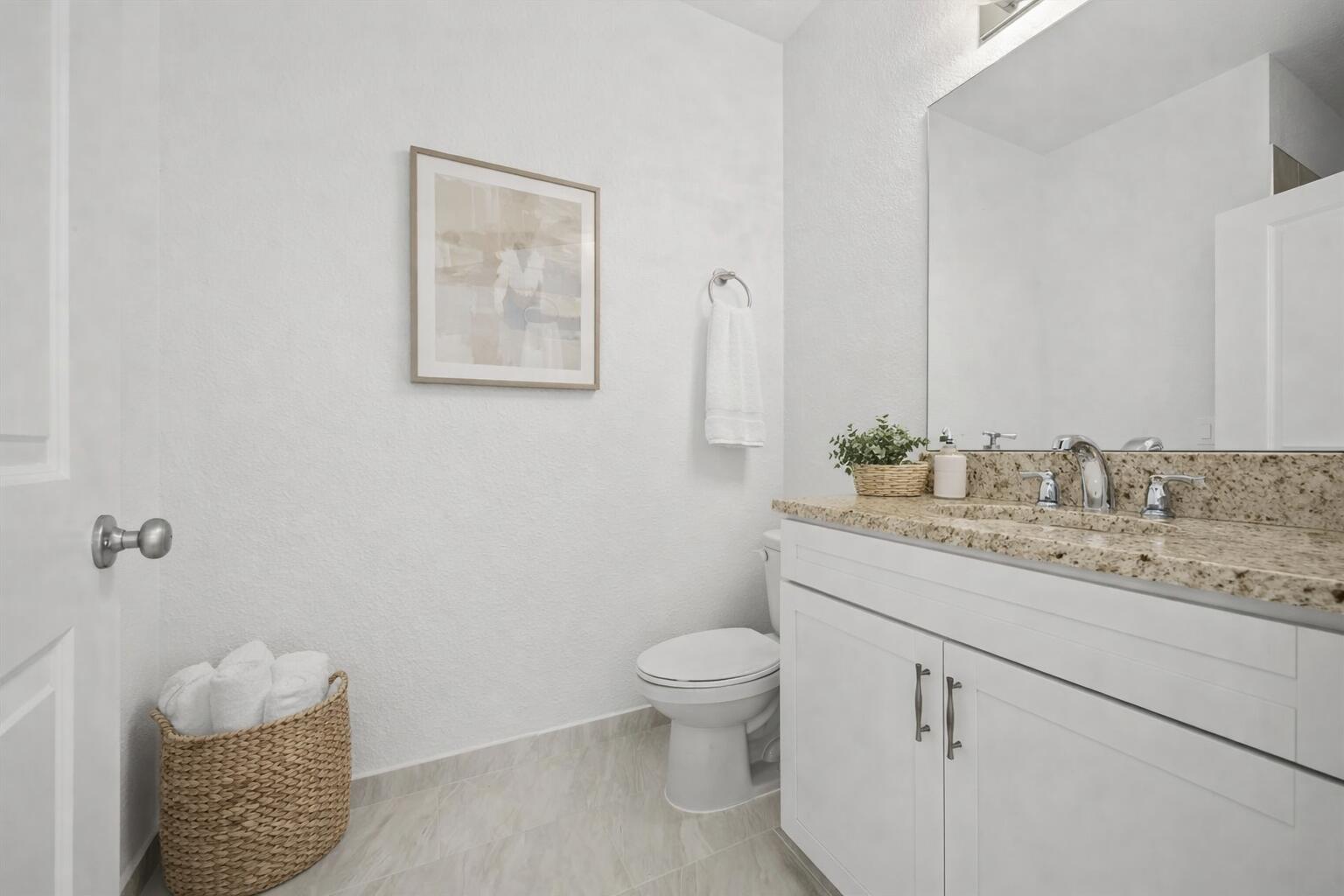 A bathroom features a white vanity with a granite countertop, a toilet, and a basket — 2575 SE Bonita Street, Stuart FL 34997, STUART, FL