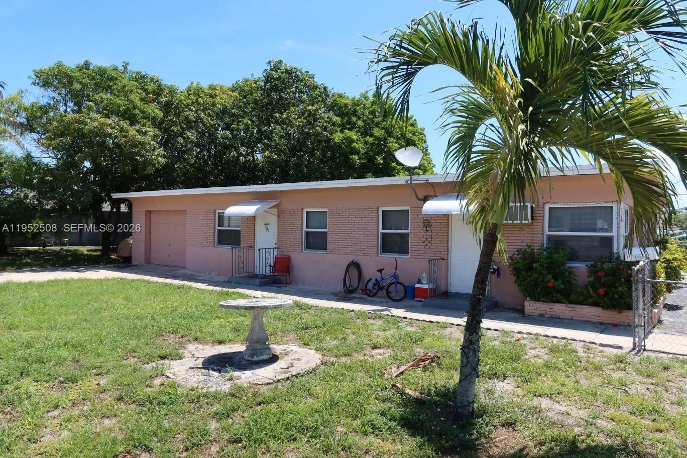 A single-story peach-colored house features a garage, two entry doors, and a front yard — 205 SE 10th St, Hallandale Beach FL 33009, HALLANDALE BEACH, FL