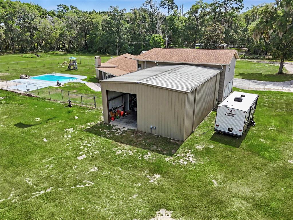 An aerial view shows a house with a detached metal garage, pool, and parked camper — 2809 NE 49TH STREET, OCALA, FL