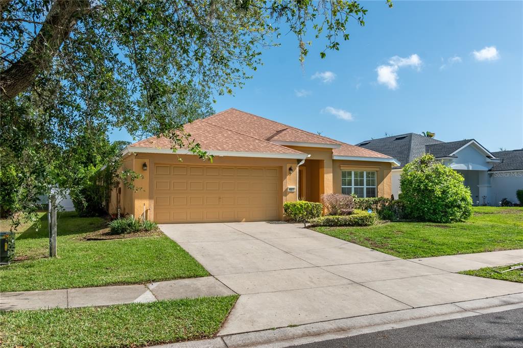 A single-story house with a tan stucco exterior, a two-car garage, and a concrete driveway — 4923 SW 40TH LANE, OCALA, FL