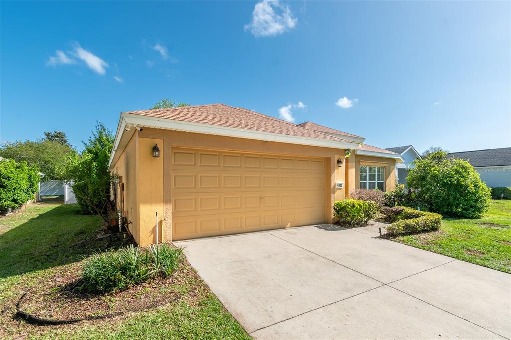 A single-story house with a tan stucco exterior, a two-car garage, and a concrete driveway — 4923 SW 40TH LANE, OCALA, FL