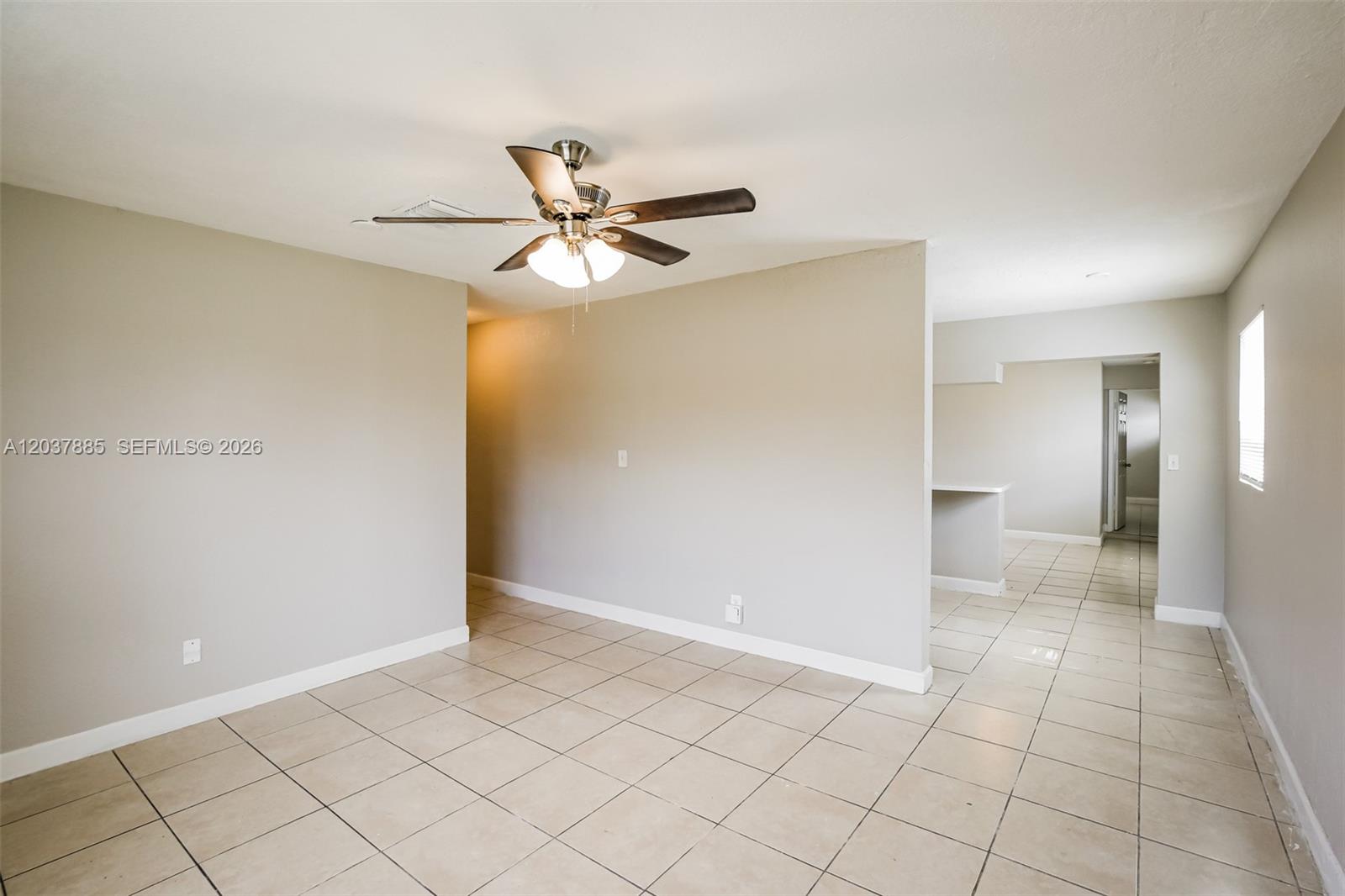An empty room with light-colored tile flooring, a ceiling fan, and neutral wall paint — 5980 NW 24th Ct, Margate FL 33063, MARGATE, FL