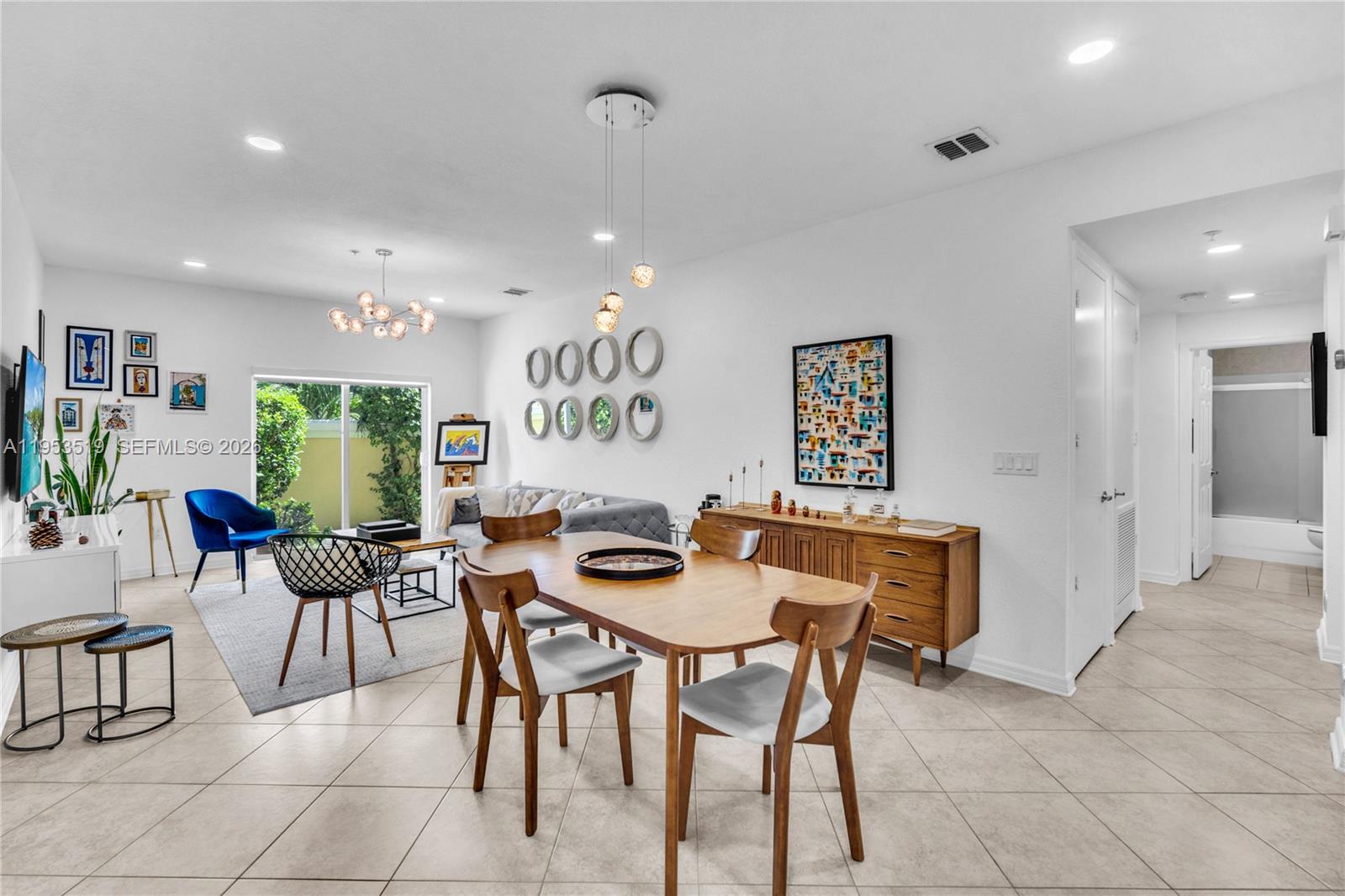 A dining area and living room feature tile floors, mid-century modern furniture, and white walls — 121 NW 2nd Ave # 4, Hallandale Beach FL 33009, HALLANDALE BEACH, FL