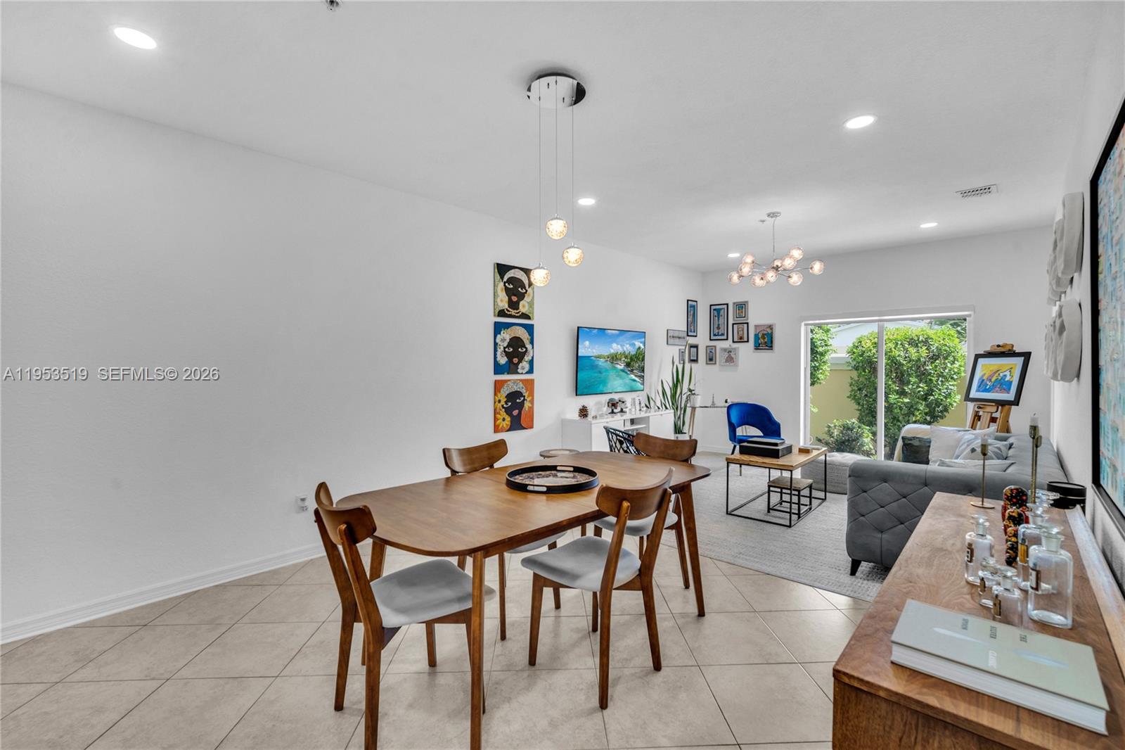 A dining area and living room feature tile flooring, modern lighting, and contemporary wall art — 121 NW 2nd Ave # 4, Hallandale Beach FL 33009, HALLANDALE BEACH, FL