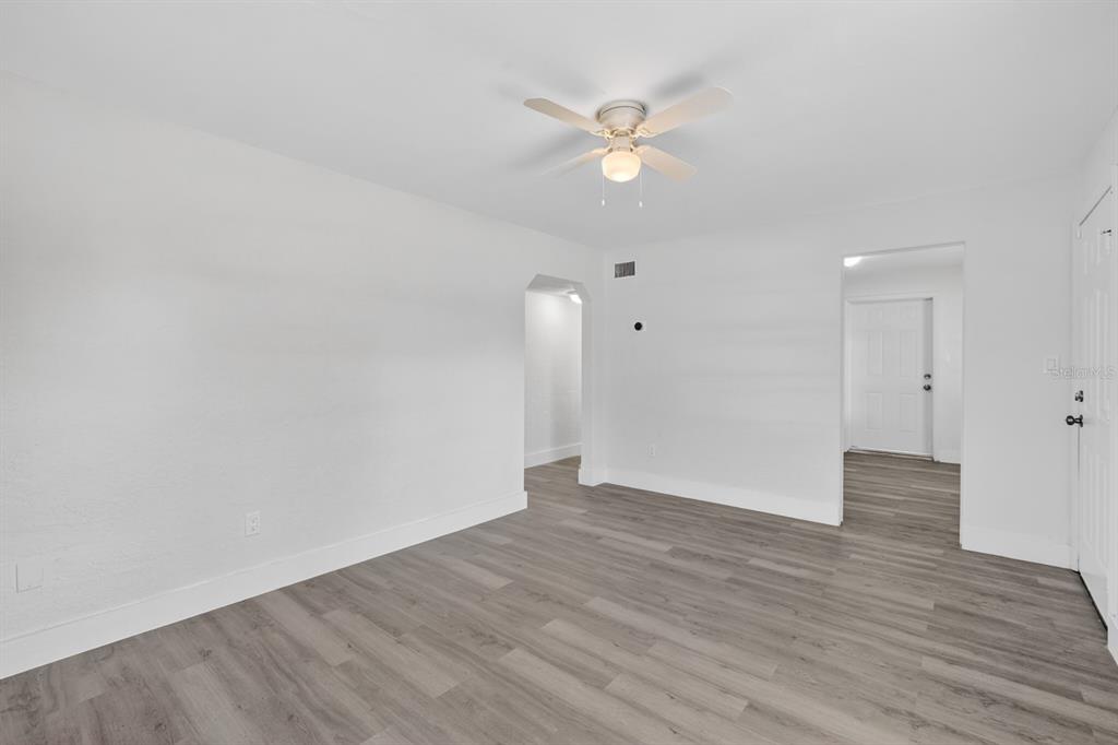 An empty room with white walls, a ceiling fan, and gray wood-look flooring — 2425 ANASTASIA DRIVE, SOUTH DAYTONA, FL