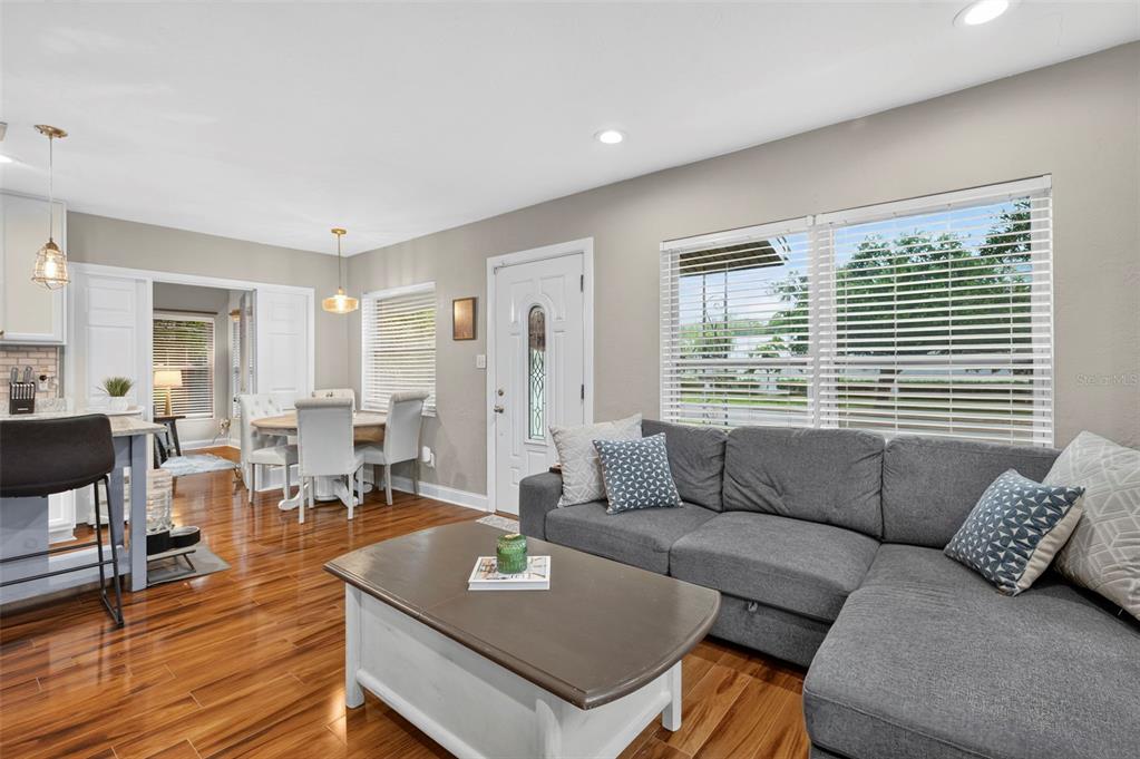 A living room with a gray sectional sofa, coffee table, and adjacent dining area — 1226 49TH AVENUE N, ST PETERSBURG, FL