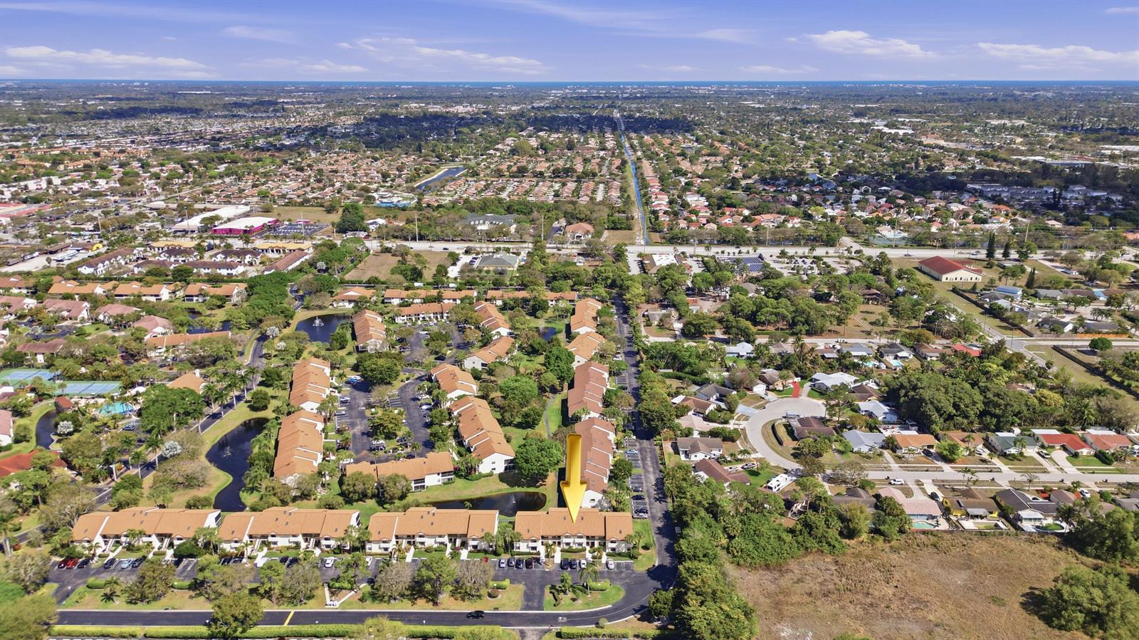 An aerial view shows a multi-unit townhouse complex with brown roofs and surrounding green space — 3260 Perimeter Drive, FL 33467, FL