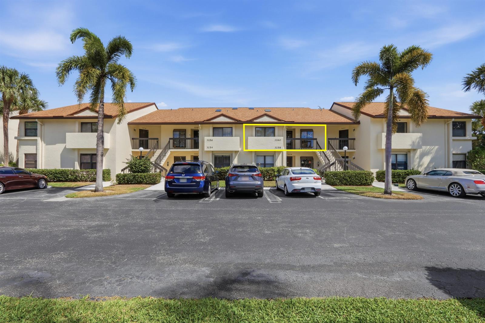 A two-story apartment building with a parking lot and palm trees in the foreground — 3260 Perimeter Drive, FL 33467, FL