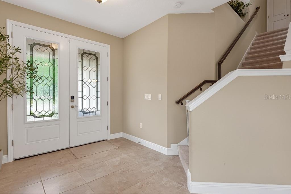 A kitchen features dark wood cabinets, stainless steel appliances, an island, and light tile flooring — 12636 SOURWOOD WAY, NEW PORT RICHEY, FL