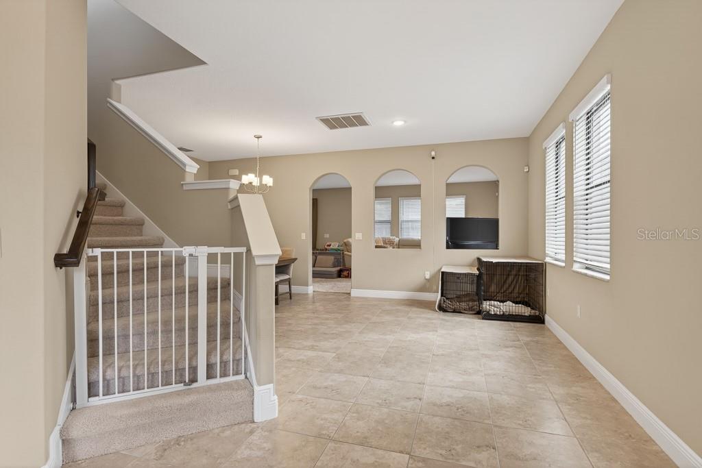 A kitchen features dark wood cabinets, stainless steel appliances, white countertops, and a central island — 12636 SOURWOOD WAY, NEW PORT RICHEY, FL