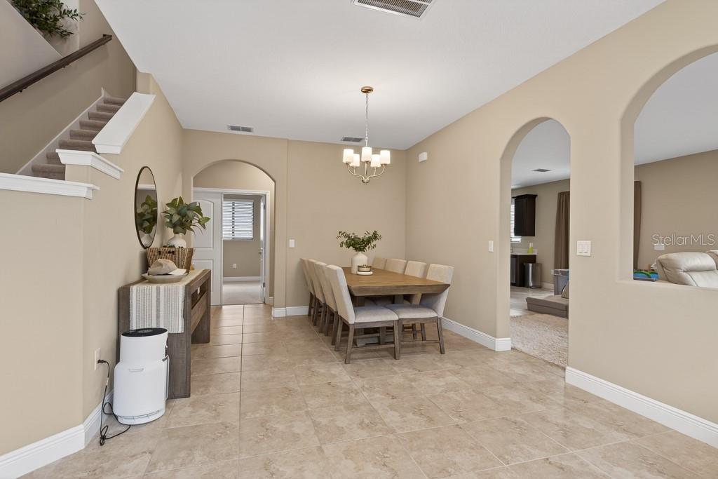 A kitchen features dark wood cabinets, white countertops, stainless steel appliances, and tile flooring — 12636 SOURWOOD WAY, NEW PORT RICHEY, FL