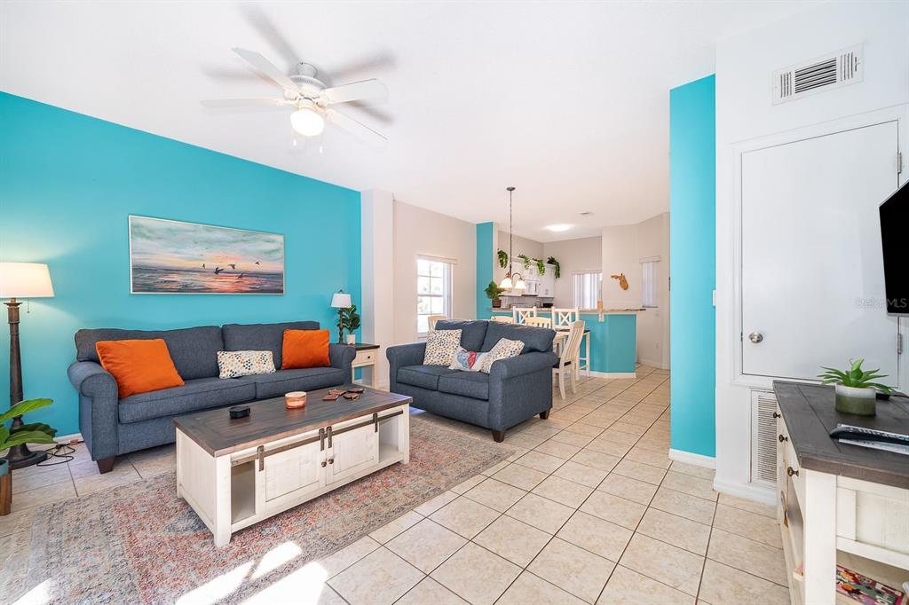A living room with blue walls, two dark sofas, and a white coffee table — 1113 PARK RIDGE CIRCLE, KISSIMMEE, FL