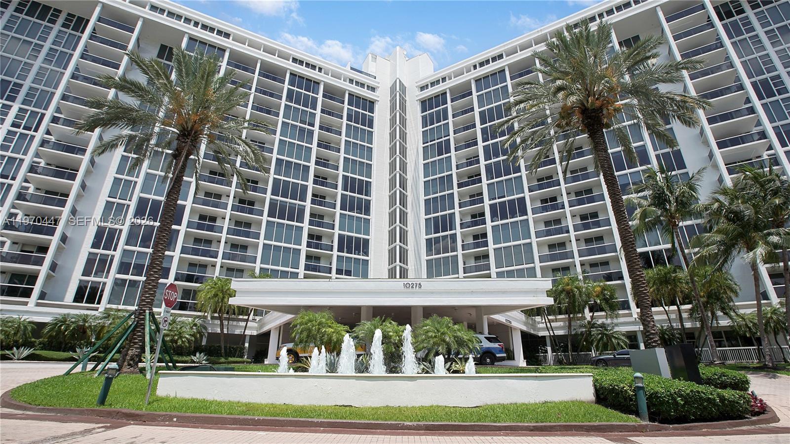 A tall white residential building features a front entrance with a fountain and palm trees — 10275 Collins Ave # 1505, Bal Harbour FL 33154, BAL HARBOUR, FL