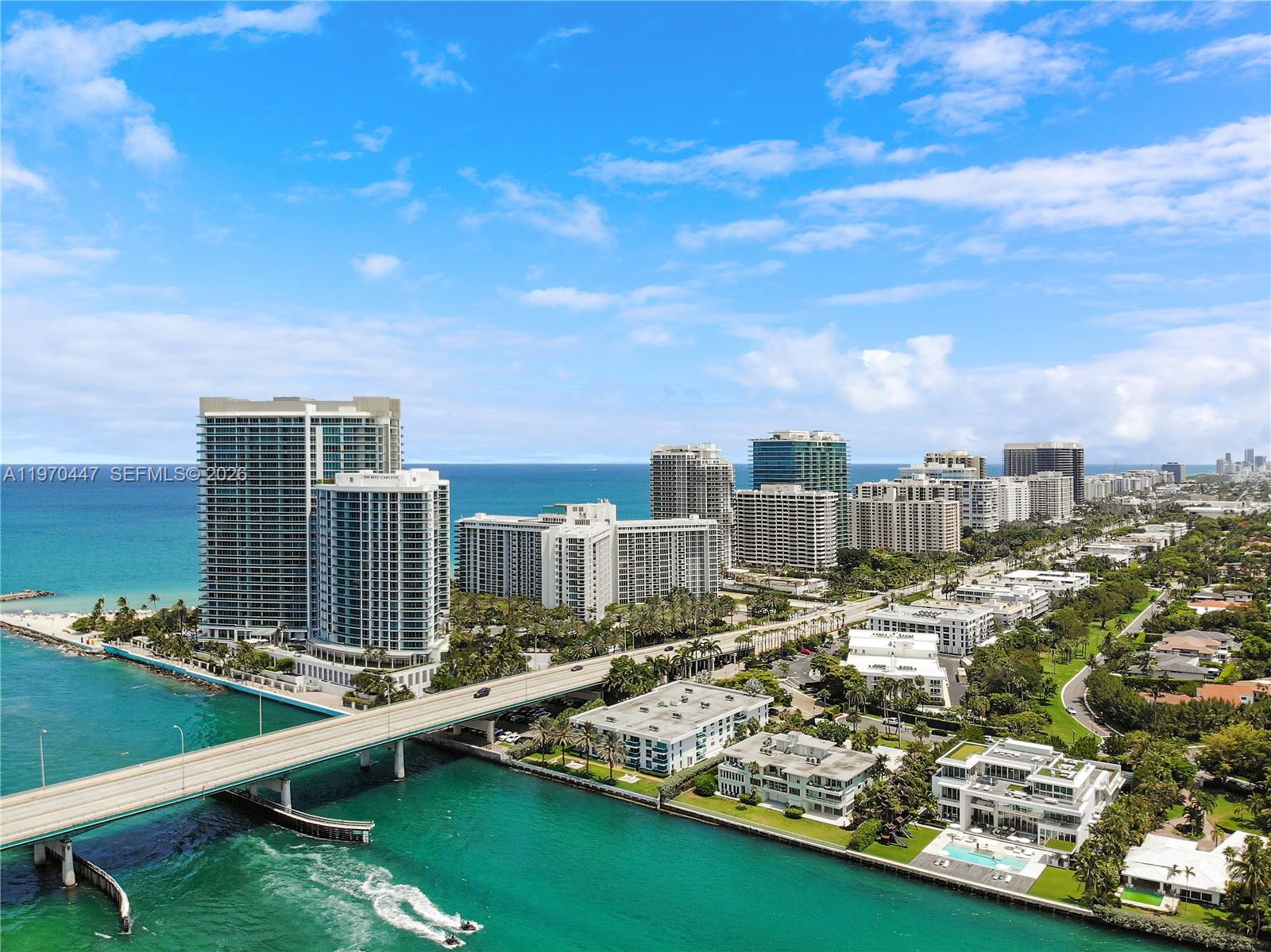 An aerial view shows high-rise buildings, a bridge over turquoise water, and coastal residential areas — 10275 Collins Ave # 1505, Bal Harbour FL 33154, BAL HARBOUR, FL
