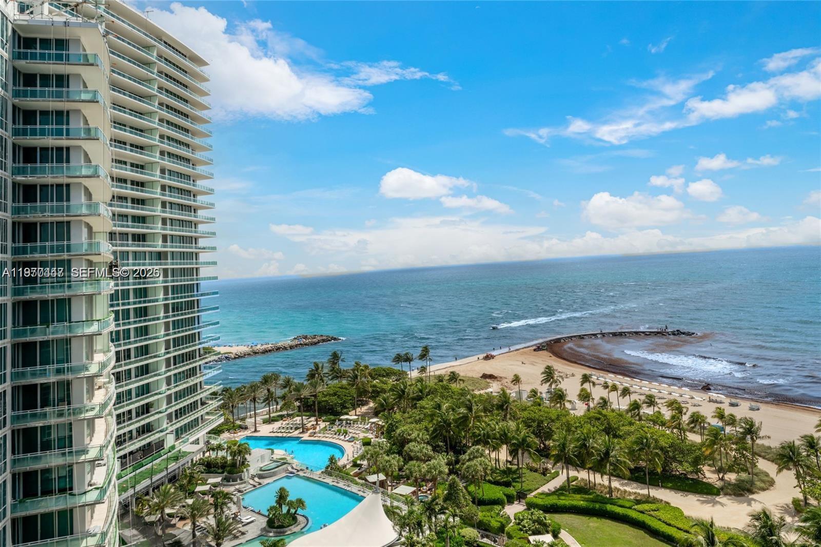 An aerial view shows a high-rise building overlooking a beach, ocean, and swimming pools — 10275 Collins Ave # 1505, Bal Harbour FL 33154, BAL HARBOUR, FL