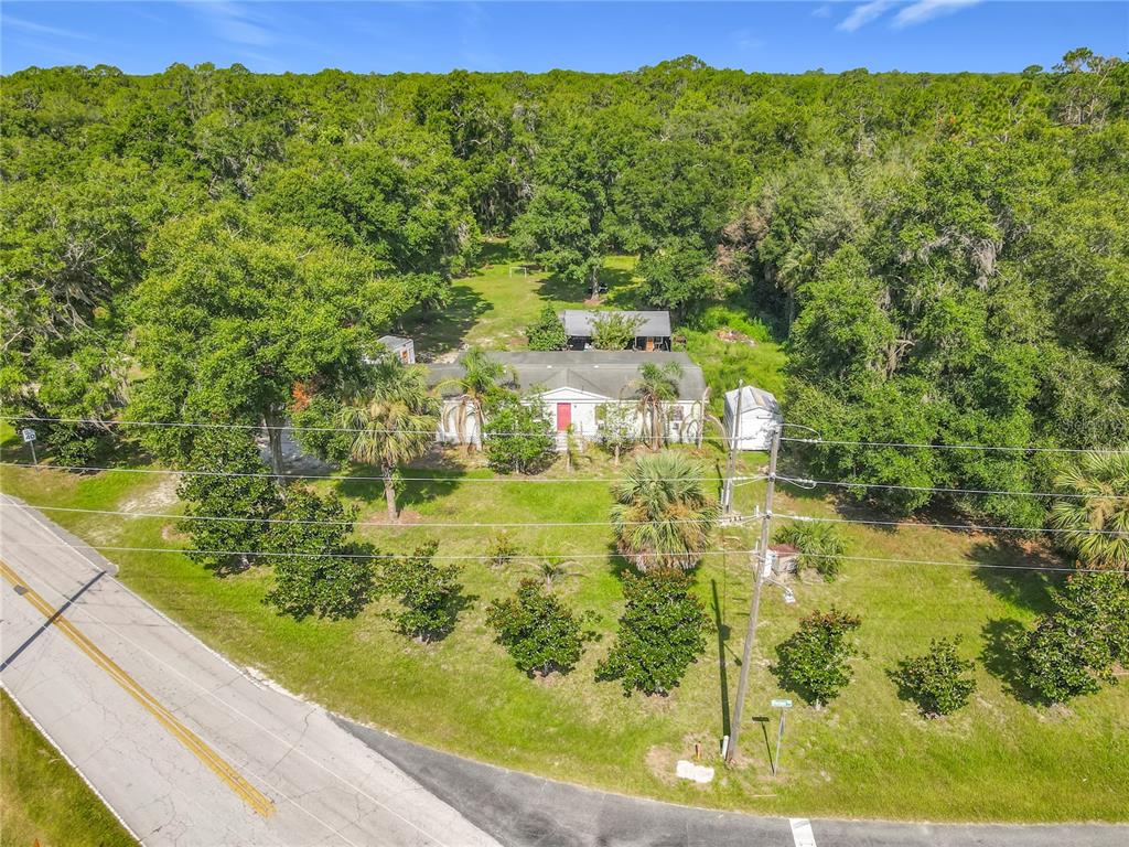 An aerial view shows a single-story house surrounded by trees near a paved road — 1116 EMPORIA ROAD, PIERSON, FL
