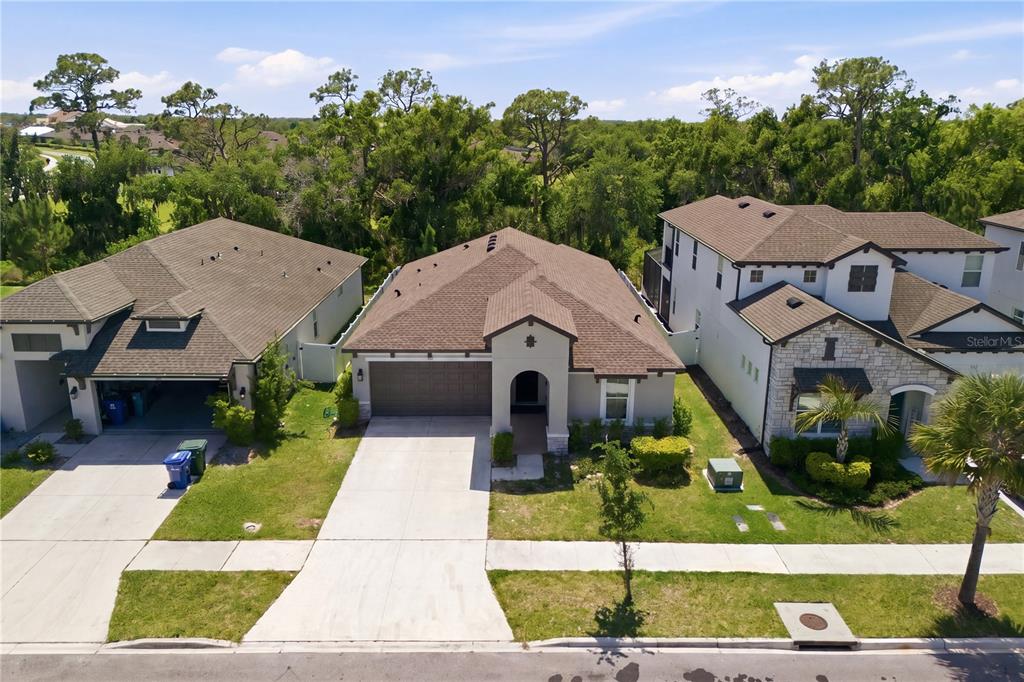 An aerial view shows three suburban houses with brown roofs and concrete driveways — 3557 SECLUDED COURT, SARASOTA, FL