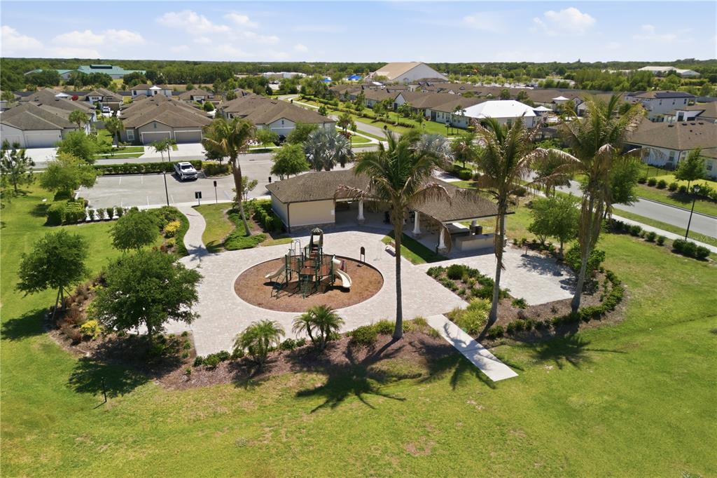 An aerial view of a neighborhood playground with a covered pavilion and paved walkways — 3557 SECLUDED COURT, SARASOTA, FL